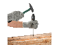 Eine Person mit Handschuhen schlägt mit einem Hammer auf einen Schraubendreher in einem Holzbalken.