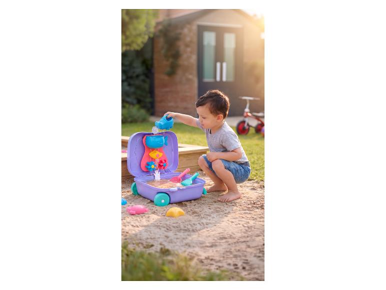 Kleinkind spielt mit einem Wasser- und Sandspieltisch im Sandkasten.