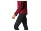 Frau in bordeauxroter Sportjacke und schwarzen Leggings mit reflektierenden Details.