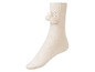 Ein Paar weiße Wollsocken mit Bommeln.