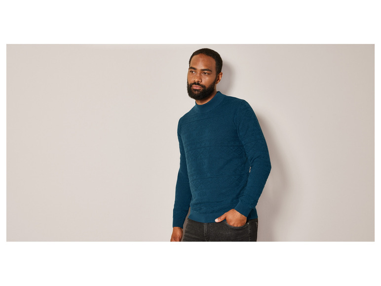 Mann in einem dunkelblauen Pullover mit Muster