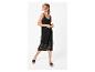 Frau in einem schwarzen Häkelkleid mit Spaghettiträgern und schwarzen Sandalen.