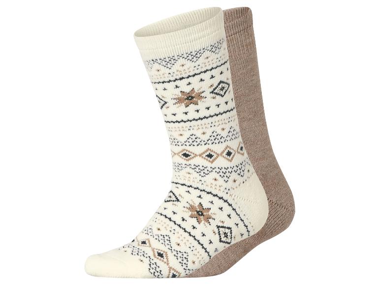Ein Paar gemütliche, gemusterte Socken in Creme und Braun.