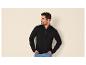 Mann in schwarzem Reißverschluss-Pullover und Jeans, lächelnd und zur Seite schauend.