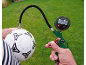 Digitales Reifendruckmessgerät pumpt einen Fußball auf grünem Rasen auf.