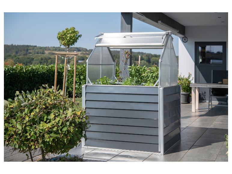 Hochbeet mit Mini-Gewächshaus auf einer Terrasse mit Naturblick.