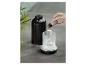 Hand fügt ätherisches Öl in einen schwarzen Aroma-Diffusor mit Wasser.