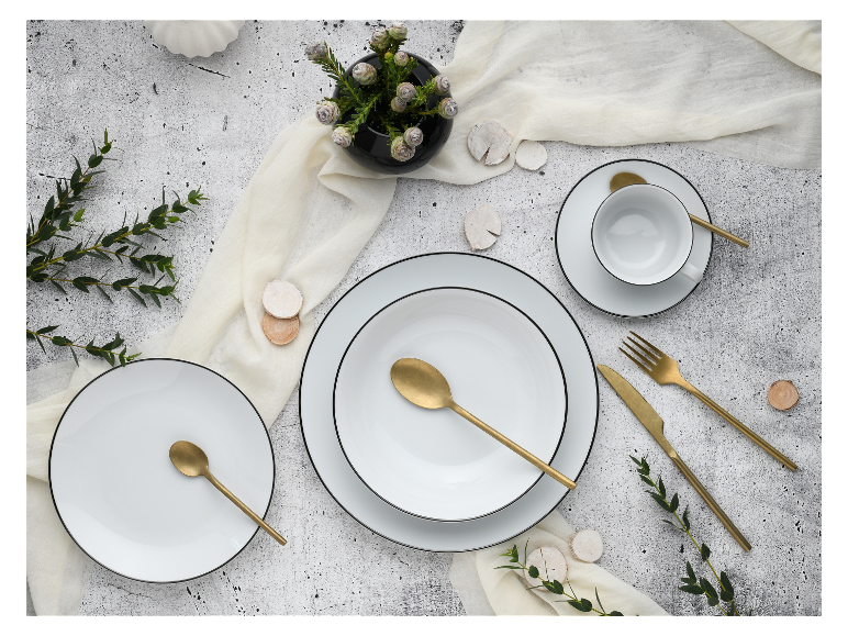 Weißes und goldenes Geschirr, goldenes Besteck, minimalistischer Stil.