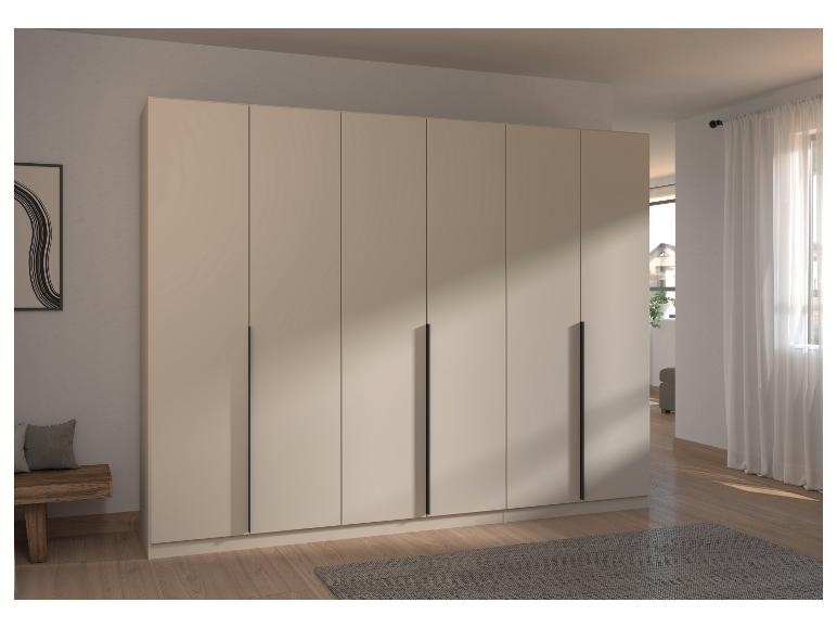 Moderner beiger Kleiderschrank mit schwarzen Griffen in einem hellen Raum mit Holzboden.