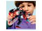 Ein Kind spielt mit einem schwarz-roten Roboterspielzeug und einer kleinen blauen Figur.