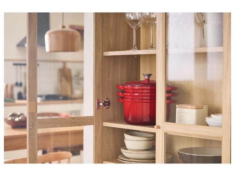 Rote Gusseisen-Töpfe und anderes Kochgeschirr in einem Holzkasten.