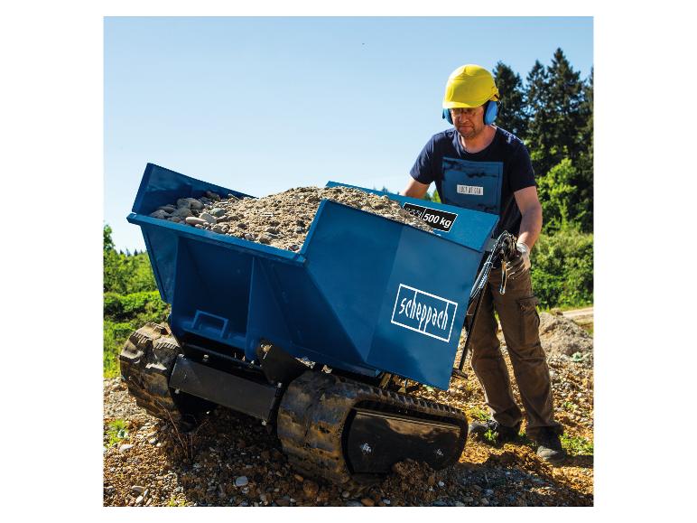 Ein Mann benutzt einen blauen Scheppach Minidumper, beladen mit Kies, auf einer Baustelle.