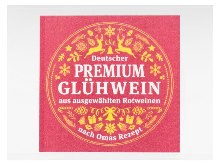 Rotes Etikett mit goldenen Weihnachtsmotiven und Text für Glühwein.