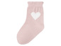 Eine rosafarbene Socke mit einem weißen Herz.