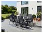 Graue Outdoor-Essgruppe auf einer sonnigen Terrasse mit Haus und Garten.