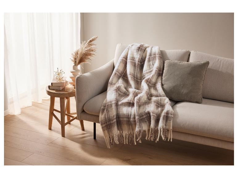 Sofa mit beigefarbener Polsterung und karierter Plaid.