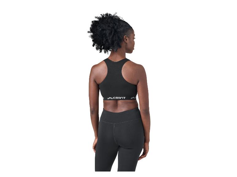 Frau von hinten in schwarzem Sport-BH und Leggings, zur Seite blickend.