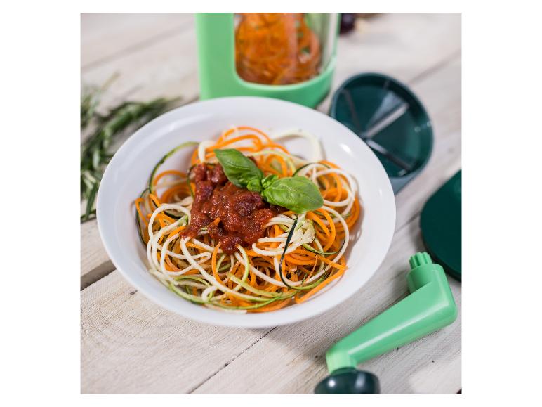 Gemüsenudeln mit Tomatensauce und Basilikum, neben einem Spiralschneider.