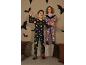 Zwei Kinder in Halloween-Pyjamas, die im Dunkeln leuchten, spielen mit Fledermausdekorationen.