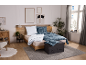 Gemütliches Schlafzimmer mit Holzbett, blauer karierter Bettwäsche und grauem Teppich.