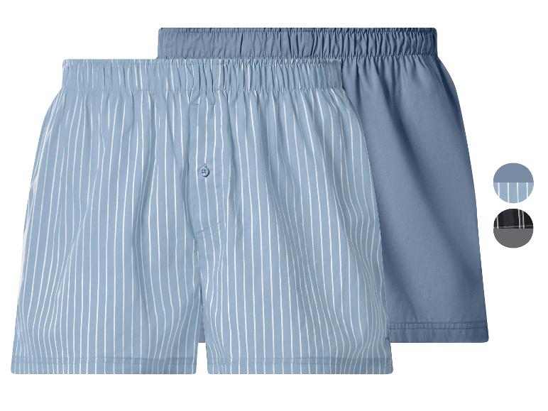Zwei blaue Boxershorts, eine gestreift und eine unifarben.
