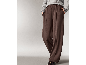 Eine Frau in einer braunen, weiten Hose und einem grauen Pullover.