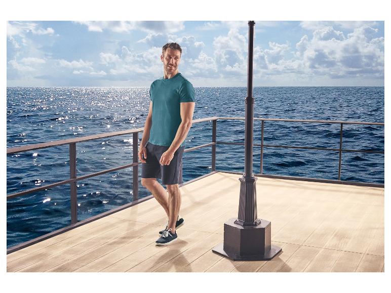 Mann in T-Shirt und Shorts, trägt ESMARA MEN Freizeitschuhe, auf einem Pier.