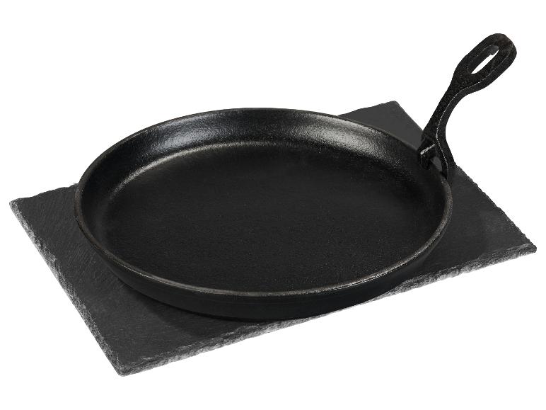 Gusseiserne Bratpfanne auf einem rechteckigen Schiefersockel.
