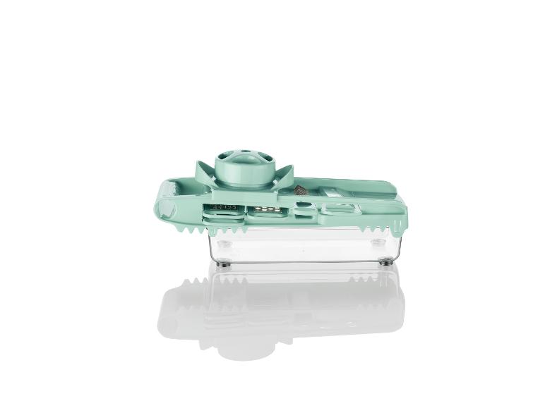 Ein grüner Gemüseschneider mit Auffangbehälter.