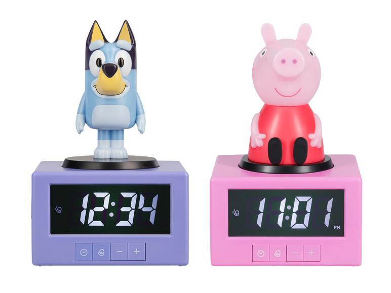 Zwei Charakter-Wecker, ein blauer Hund und ein rosa Schwein, die unterschiedliche Zeiten anzeigen.