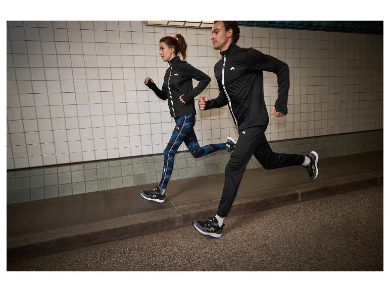 Zwei Läufer in schwarzer und blauer Sportkleidung, in einem Tunnel.