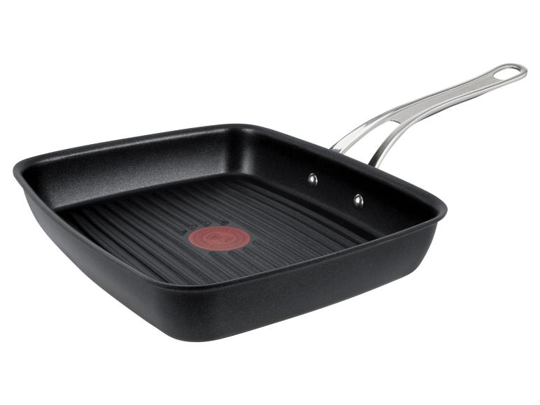 Schwarze quadratische Grillpfanne mit geriffelter Oberfläche und Metallgriff.