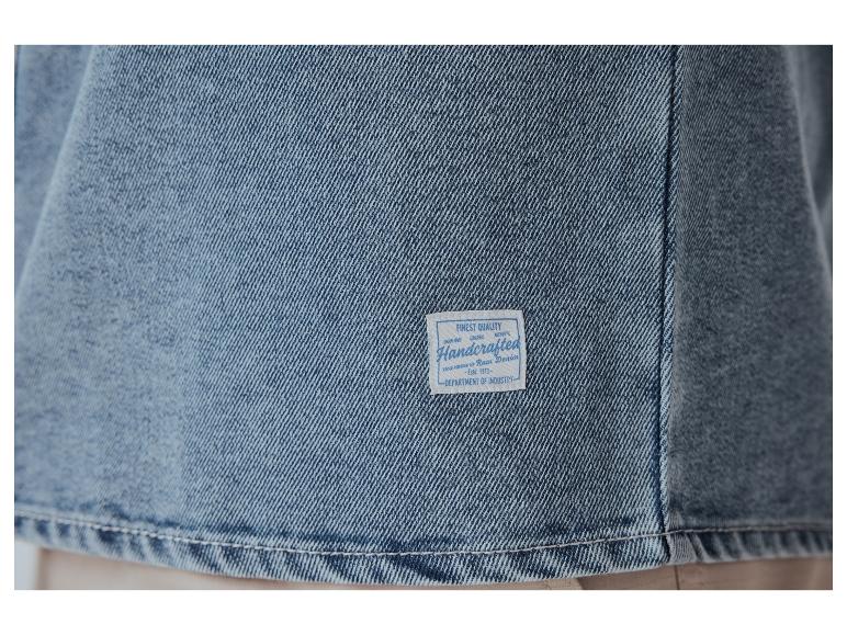 Nahaufnahme von Jeansstoff mit einem Etikett mit der Aufschrift 'Handcrafted Raw Denim'.