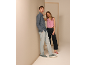 Mann in blauem Leinenhemd und Frau in rosa Weste und dunkler Hose.