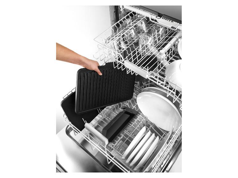 Eine Hand legt eine schwarze Grillplatte in einen Geschirrspüler voller Geschirr.