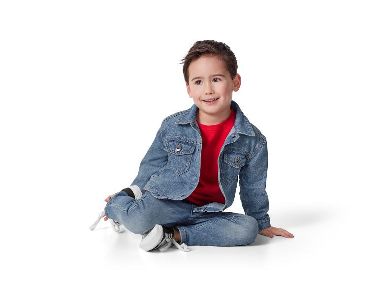 Lächelndes Kind in Jeans und Jeansjacke.