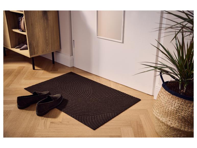 Braune LIVARNO® Schmutzfangmatte mit Wellenmuster an der Tür.