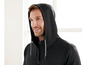 Ein Mann trägt eine schwarze Kapuzenjacke mit Reißverschluss.