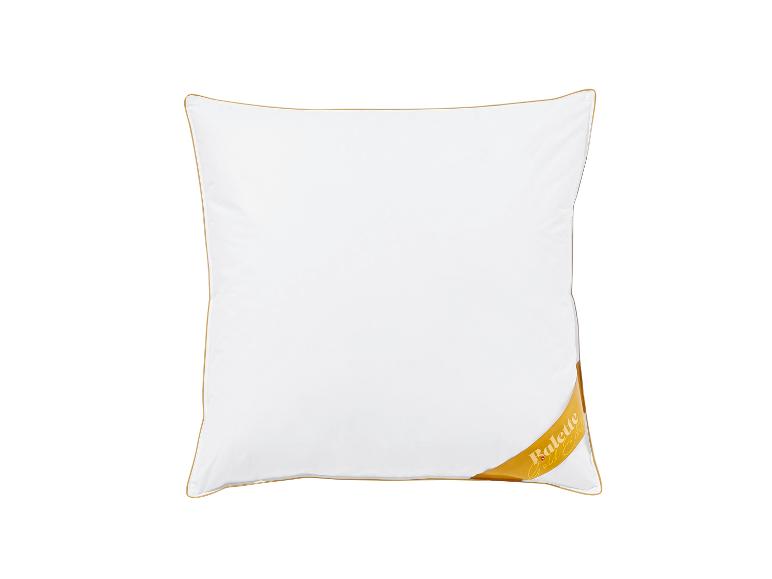 Weißes Kissen mit goldener Paspelierung und goldenem Etikett