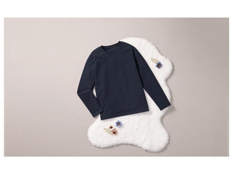 Ein dunkelblaues Langarmshirt auf einem weißen, flauschigen Untergrund.