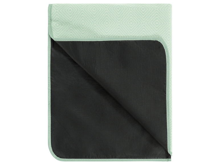 Eine gefaltete Picknickdecke mit grünem, geometrischem Muster.