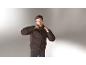 Mann in einer dunkelbraunen Herren-Daunenjacke und grauer Hose.