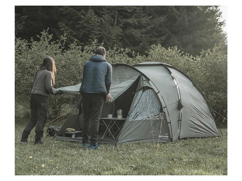 Zwei Personen bauen ein Easy Camp-Zelt im Wald auf.