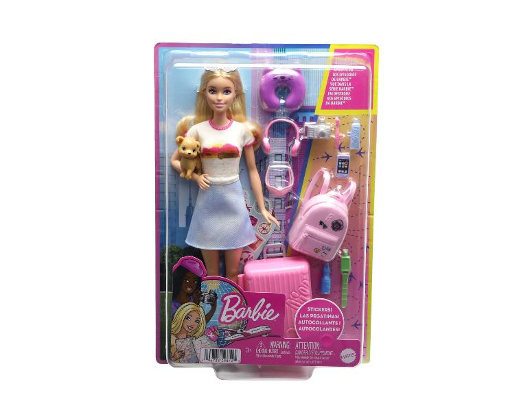 Puppe mit Reisezubehör, darunter Koffer, Rucksack und Haustier.