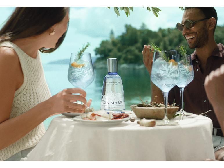 Paar genießt Gin Tonic und Snacks im Freien.