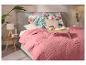 Schlafzimmer mit rosa Tagesdecke, Kissen mit Blumenmuster und einem hölzernen Frühstückstablett.