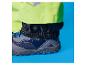 Nahaufnahme des Fußes einer Person in neongrüner Regenhose und dunkelblauem Schuh.