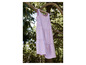 Ein rosa Sommerkleid hängt an einem Ast im Baum.