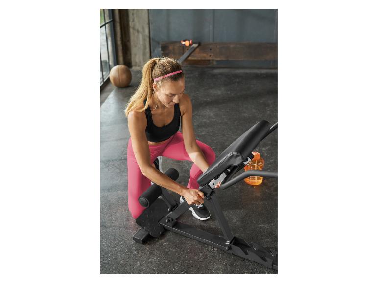 Frau stellt eine Hantelbank in einem Fitnessstudio ein.