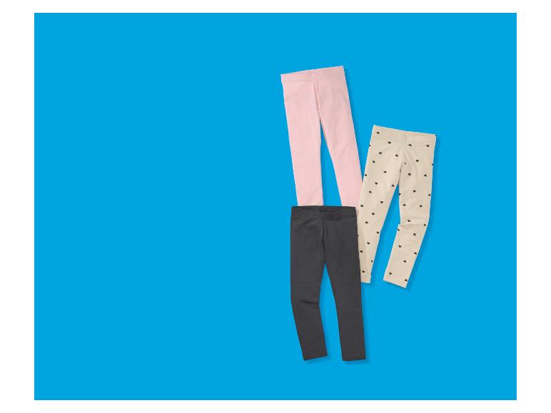 Drei Kinderleggings: rosa, grau und beige mit schwarzen Herzen.
